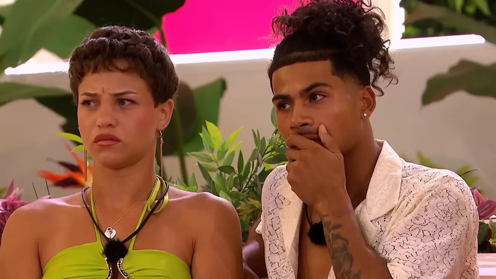 Two islanders on the couch, one pressing a hand flat over his mouth.