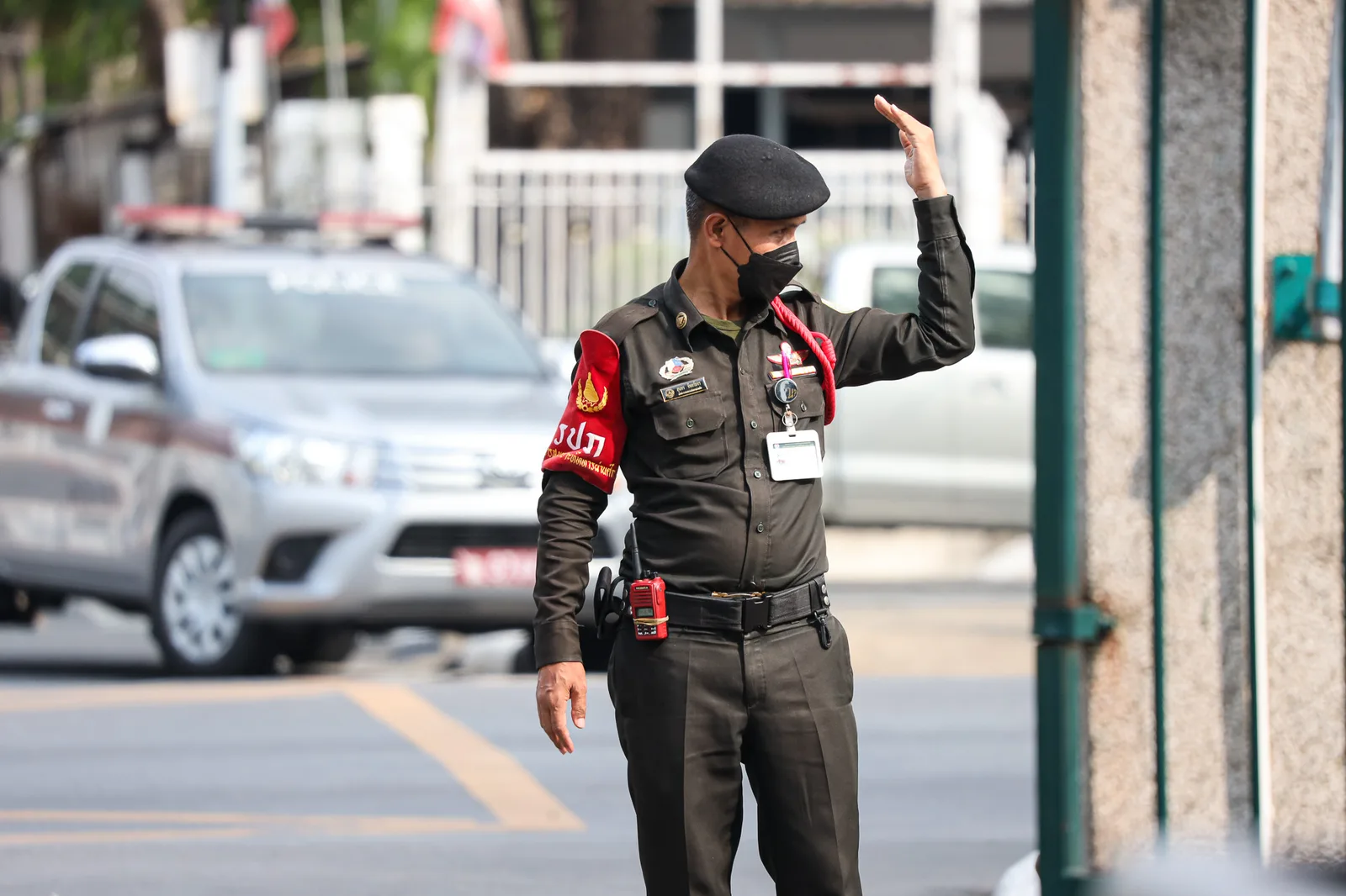 security guard under The Office of Security, The War Veterans Organization of Thailand is directing traffic in front of the ALRO.